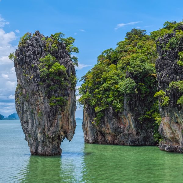 green and brown rock formation on blue sea under blue sky during daytime